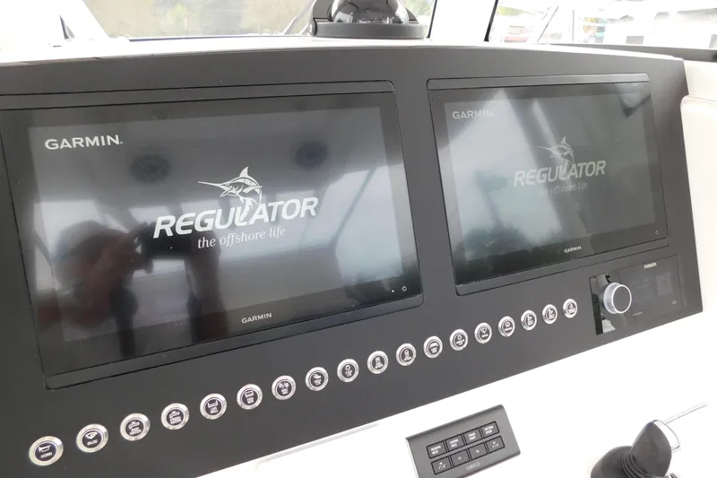 Slide: The Image of 2026 Regulator 28 boat dashboard with dual Garmin displays and control panel. - 39