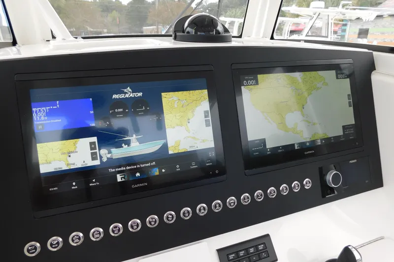 Slide: The Image of 2026 Regulator 28 boat dashboard with dual Garmin navigation screens and control panel. - 44