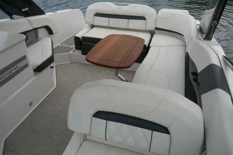Slide: The Image of 2019 Regal 26 FasDeck boat interior with white seating and wooden table. - 16