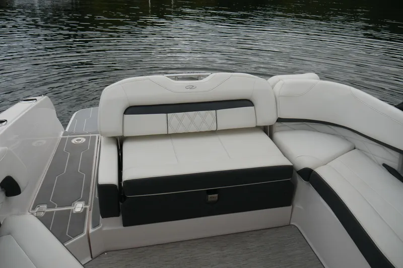 Slide: The Image of 2019 Regal 26 FasDeck boat interior with white and black seating by the water. - 17