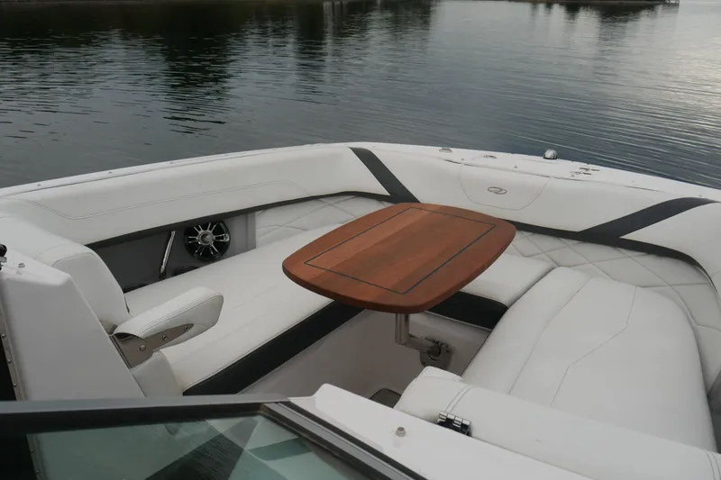 Slide: The Image of 2019 Regal 26 FasDeck boat interior with white seating and wooden table. - 20