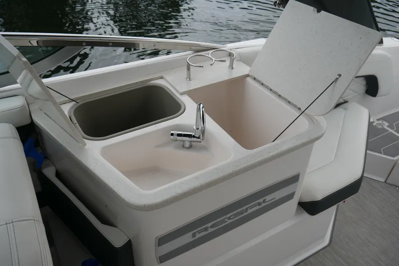 Slide: The Image of 2019 Regal 26 FasDeck boat sink and storage area with cup holders. - 25