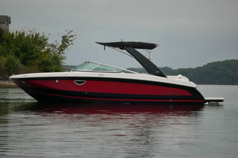 Slide: The Image of 2019 Regal 26 FasDeck boat on calm water, featuring sleek red and black design. - 3