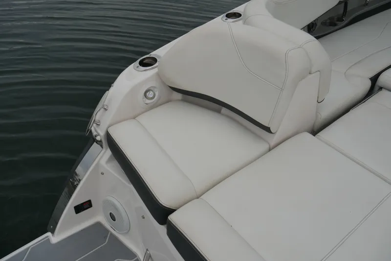 Slide: The Image of 2019 Regal 26 FasDeck boat with white cushioned seating by the water. - 30