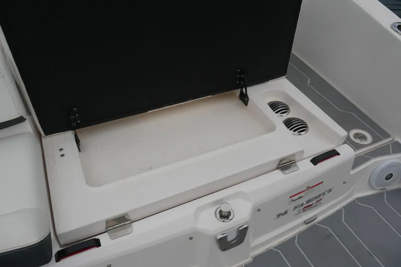 Slide: The Image of 2019 Regal 26 FasDeck boat storage compartment with open lid and drainage vents. - 32