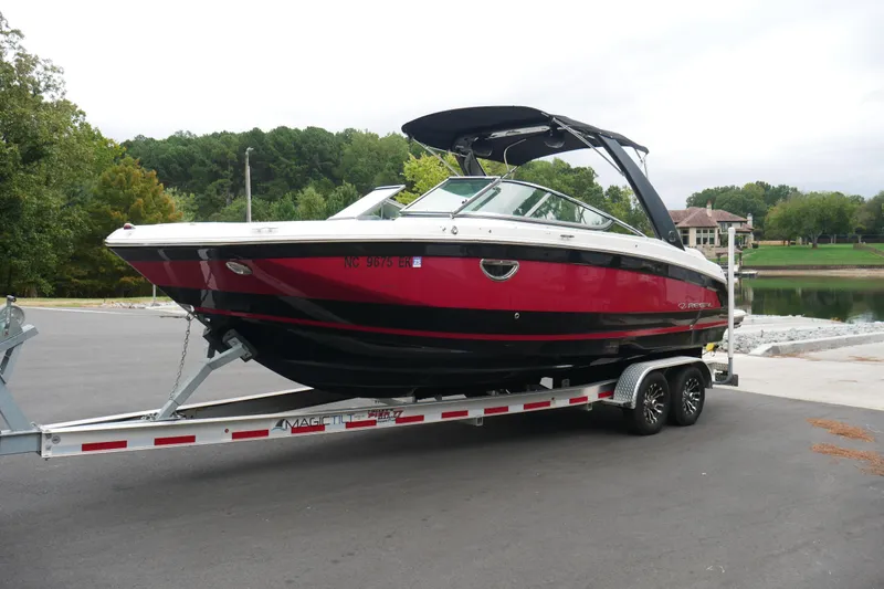 Slide: The Image of 2019 Regal 26 FasDeck boat on trailer, parked near a scenic lake. - 35