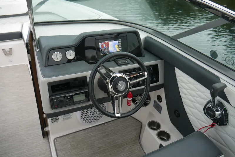 Slide: The Image of 2019 Regal 26 FasDeck boat dashboard with steering wheel and control panel. - 9