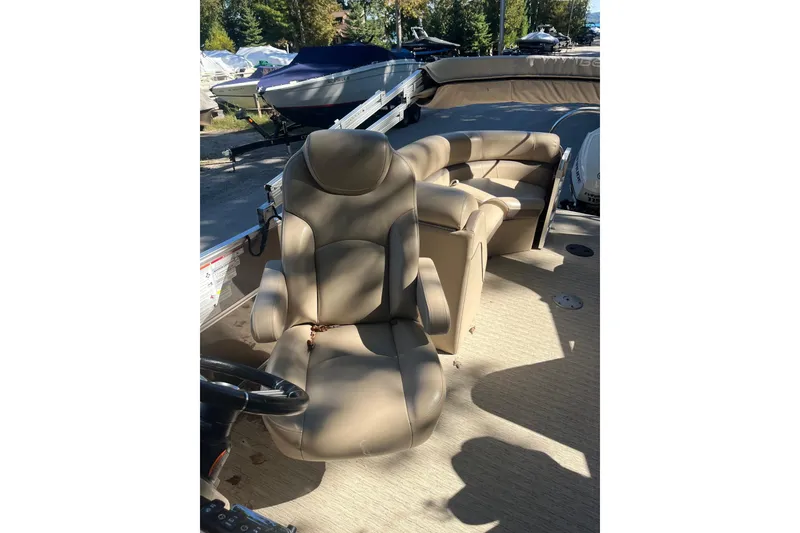 Slide: The Image of 2018 Berkshire 22 Quad Bench Tritoon with beige seating and steering wheel. - 2