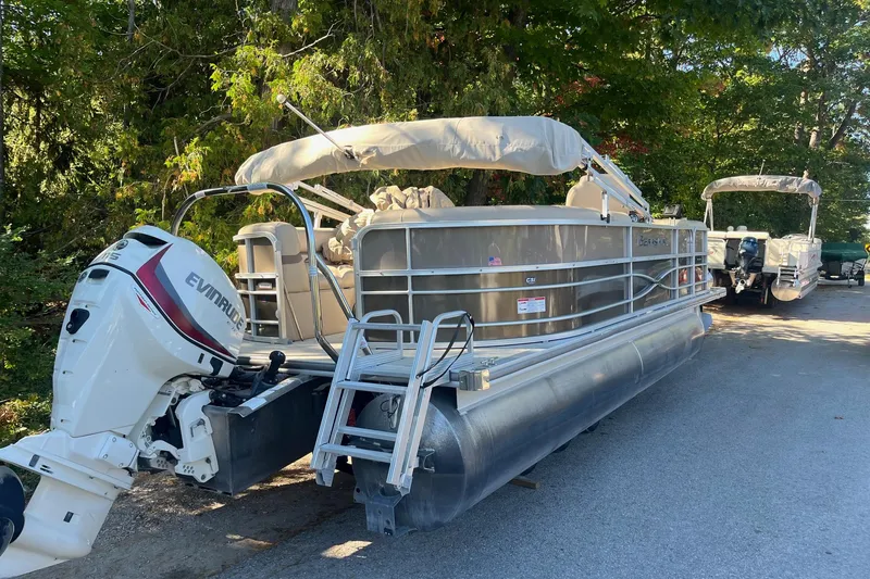 Slide: The Image of 2018 Berkshire 22 Quad Bench Tritoon with Evinrude engine, parked outdoors. - 6