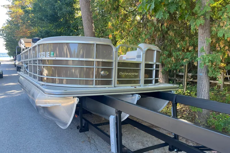 Slide: The Image of 2018 Berkshire 22 Quad Bench Tritoon on trailer, surrounded by trees. - 8