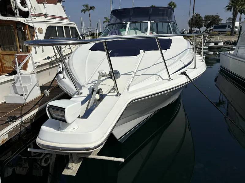 The Image of 1998 Trojan 400 boat docked at marina, featuring sleek design and spacious deck. - 0