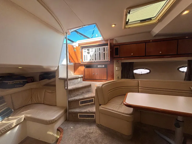 Slide: The Image of Interior of a 1998 Trojan 400 yacht with beige seating and wooden cabinetry. - 11