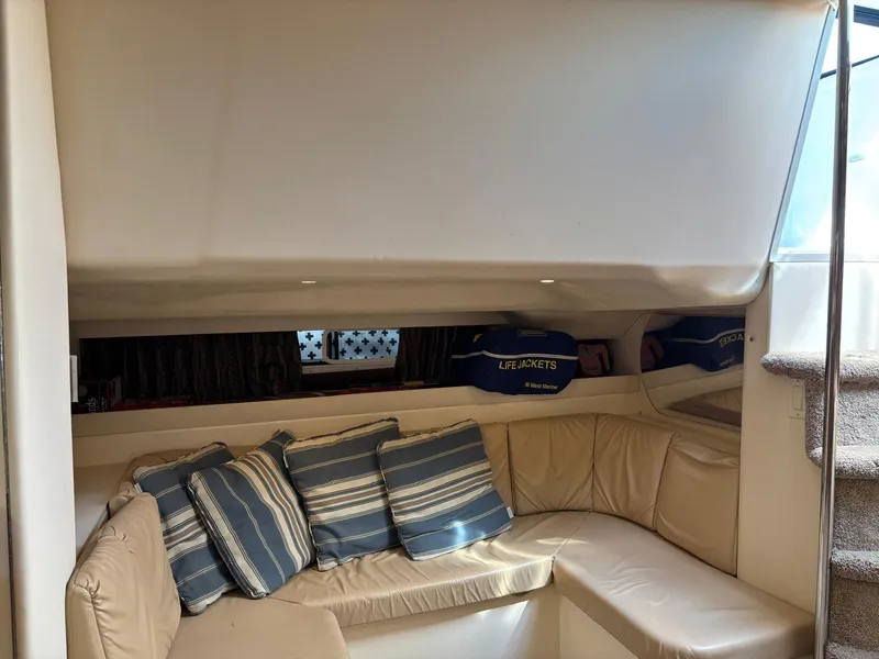 Slide: The Image of Interior of a 1998 Trojan 400 yacht with beige seating and striped cushions. - 16