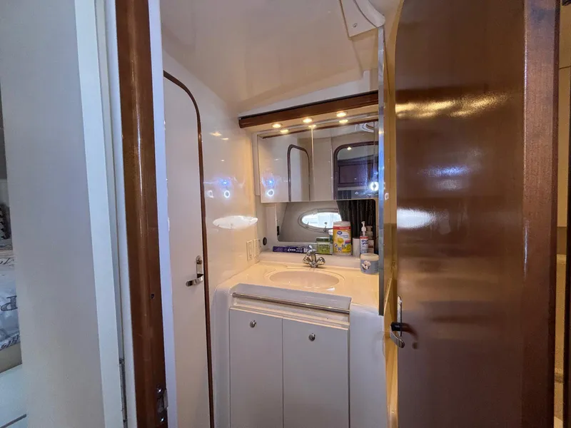 Slide: The Image of 1998 Trojan 400 yacht bathroom with sink, mirror, and storage cabinets. - 21