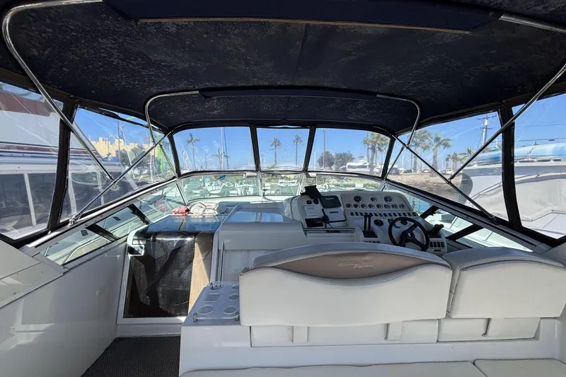 Slide: The Image of 1998 Trojan 400 boat cockpit with steering wheel, control panel, and seating under canopy. - 3
