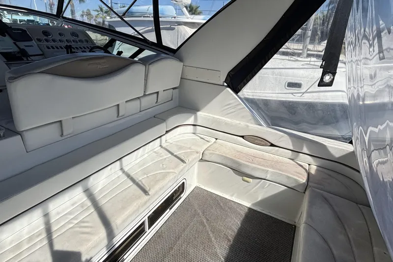 Slide: The Image of Interior of a 1998 Trojan 400 yacht with white seating and control panel. - 9
