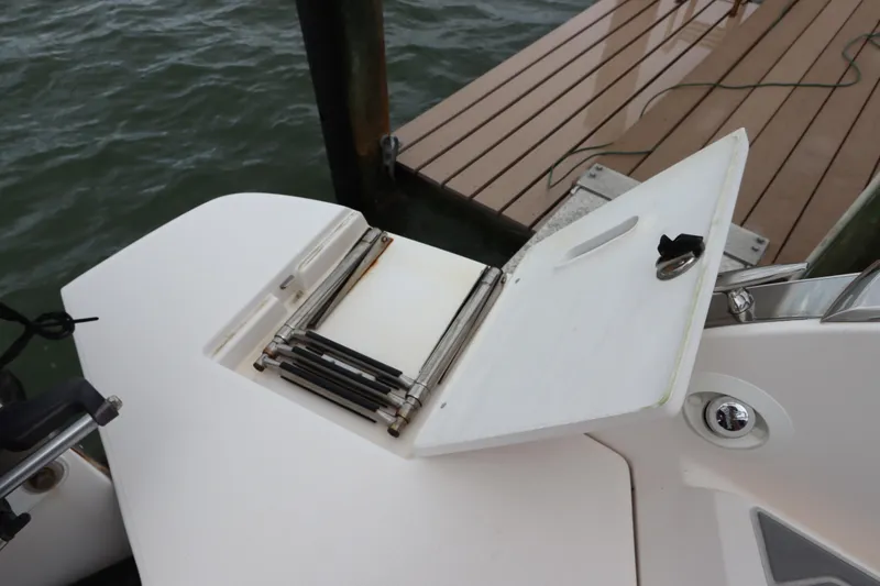 Slide: The Image of 2018 Regal 29 OBX boat with foldable swim ladder near dock. - 10