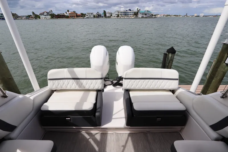 Slide: The Image of 2018 Regal 29 OBX boat with dual outboard engines, docked by waterfront homes. - 16