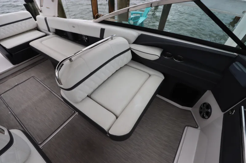 Slide: The Image of 2018 Regal 29 OBX boat interior with white leather seating and cup holders. - 19