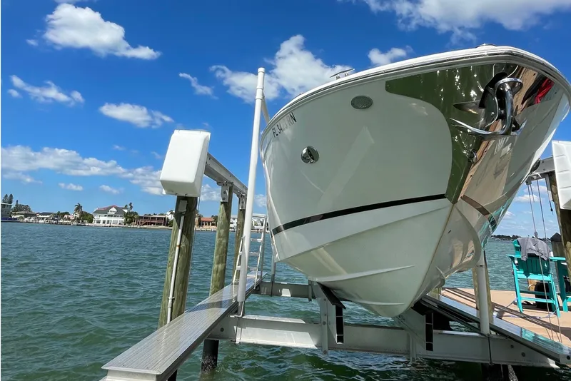 Slide: The Image of 2018 Regal 29 OBX boat on lift, clear sky, waterfront view. - 2