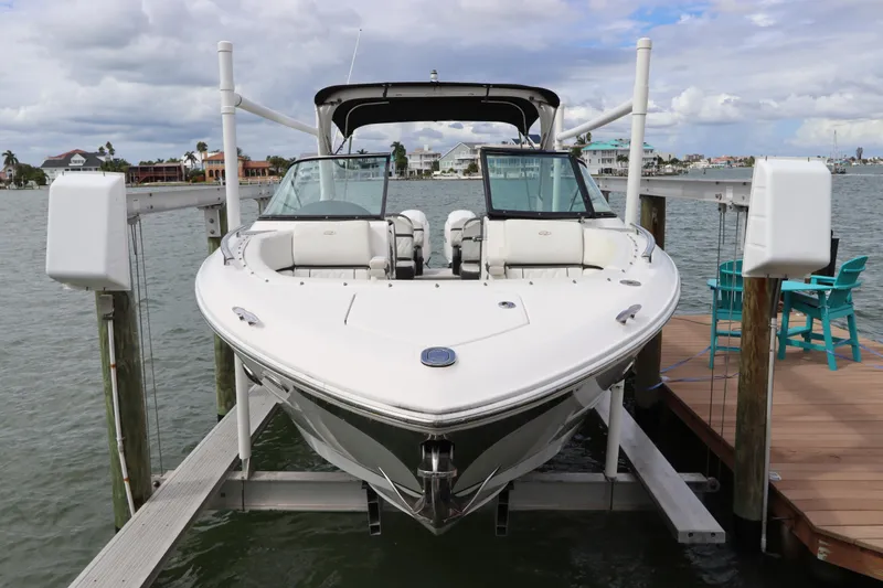 Slide: The Image of 2018 Regal 29 OBX boat docked on a lift by waterfront homes. - 6