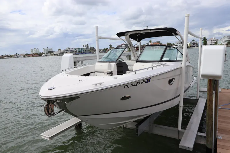 Slide: The Image of 2018 Regal 29 OBX boat docked on a lift, with scenic waterfront background. - 7