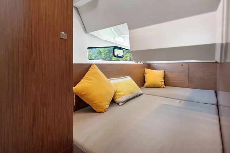Slide: The Image of Interior of 2026 Jeanneau NC 1095 Coupe with cozy seating and yellow cushions. - 9