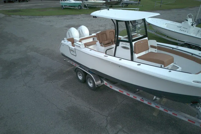 Slide: The Image of 2026 Sea Hunt Gamefish 27 Coffin Box boat on trailer, featuring dual engines and spacious seating. - 8