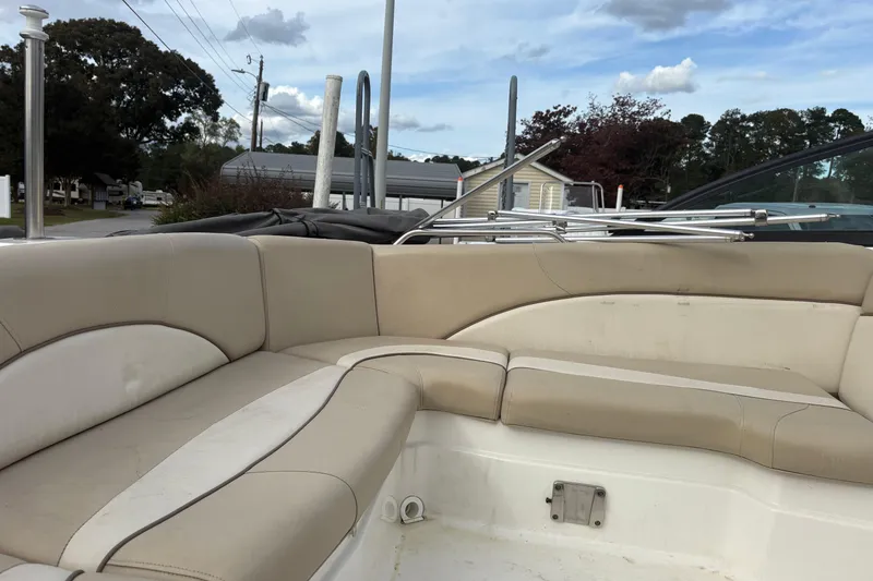 Slide: The Image of 2022 NauticStar 203 DC boat interior with beige seating and outdoor background. - 11