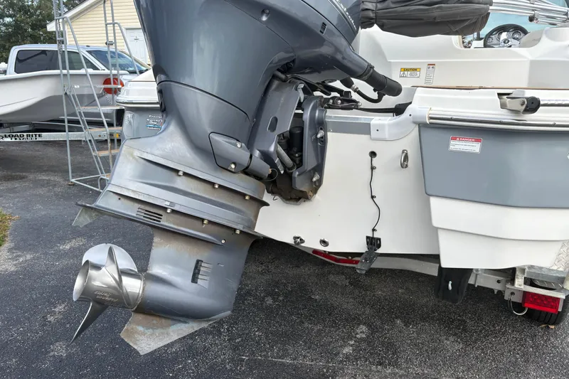 Slide: The Image of 2022 NauticStar 203 DC boat with outboard motor, parked on a driveway. - 13