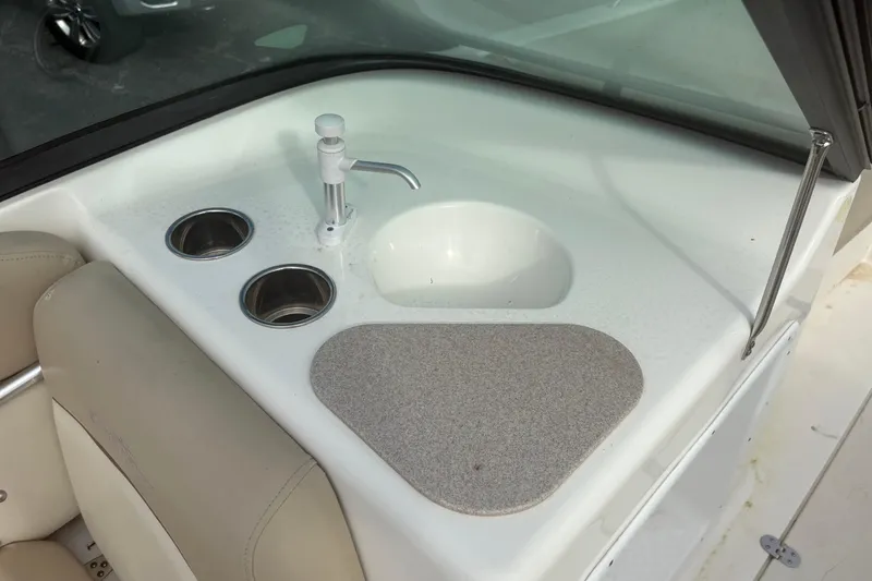 Slide: The Image of 2022 NauticStar 203 DC boat interior with sink and cup holders. - 16