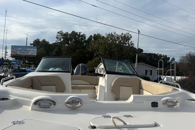 Slide: The Image of 2022 NauticStar 203 DC boat with beige seating, parked outdoors under cloudy sky. - 4