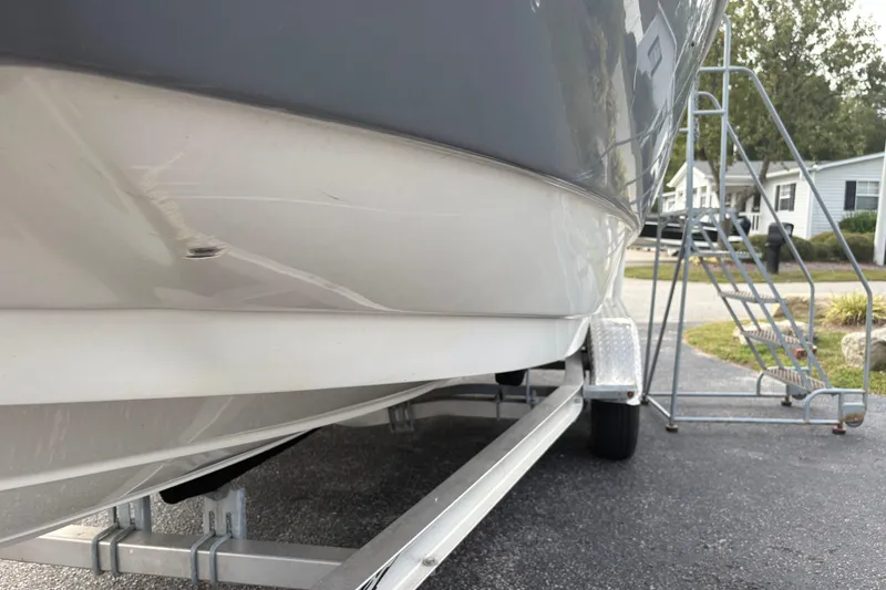 Slide: The Image of 2022 NauticStar 203 DC boat on trailer, side view, parked outdoors. - 6