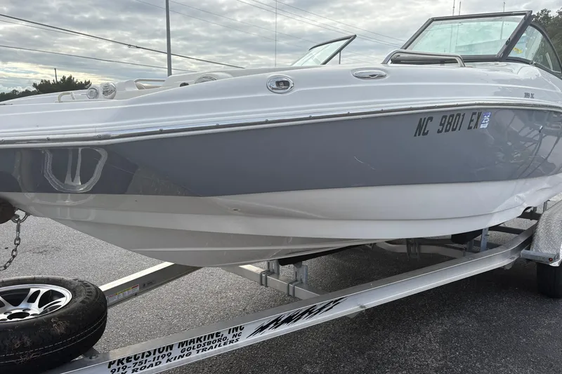 Slide: The Image of 2022 NauticStar 203 DC boat on trailer, gray and white exterior, parked outdoors. - 7