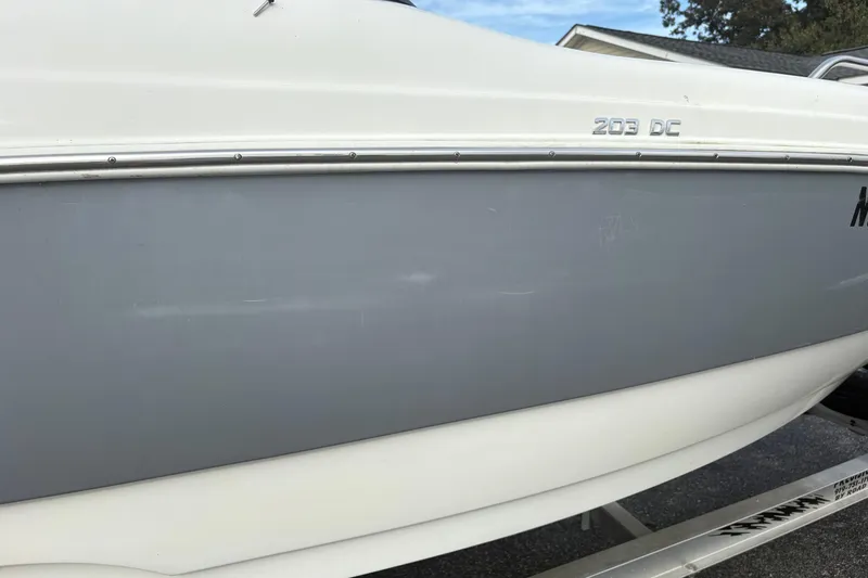 Slide: The Image of 2022 NauticStar 203 DC boat side view, featuring sleek gray and white design. - 9