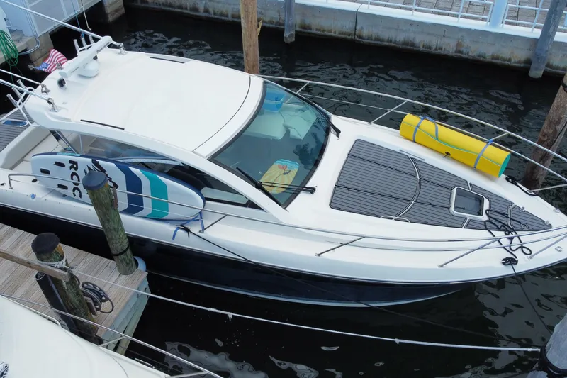 Slide: The Image of 2014 Pursuit SC 365i Sport Coupe docked at marina, front view with nautical equipment. - 10
