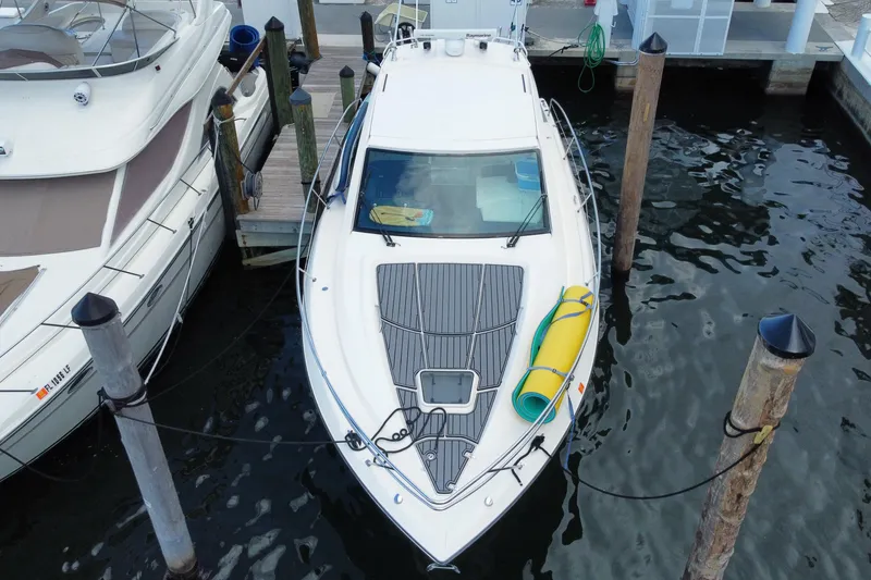 Slide: The Image of 2014 Pursuit SC 365i Sport Coupe docked at marina, under cloudy sky. - 12