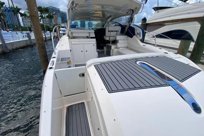 Slide: The Image of 2014 Pursuit SC 365i Sport Coupe docked, showcasing spacious deck and seating area. - 21