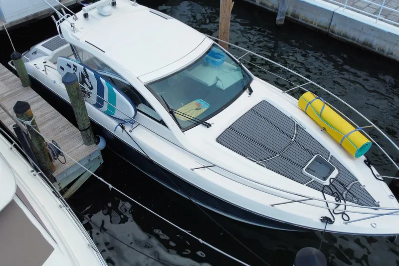 Slide: The Image of 2014 Pursuit SC 365i Sport Coupe docked at marina, blue hull, sleek design. - 3