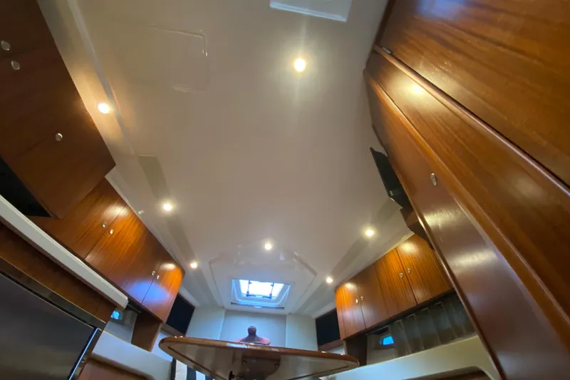 Slide: The Image of Interior of 2014 Pursuit SC 365i Sport Coupe with wooden table and cushioned seating. - 46