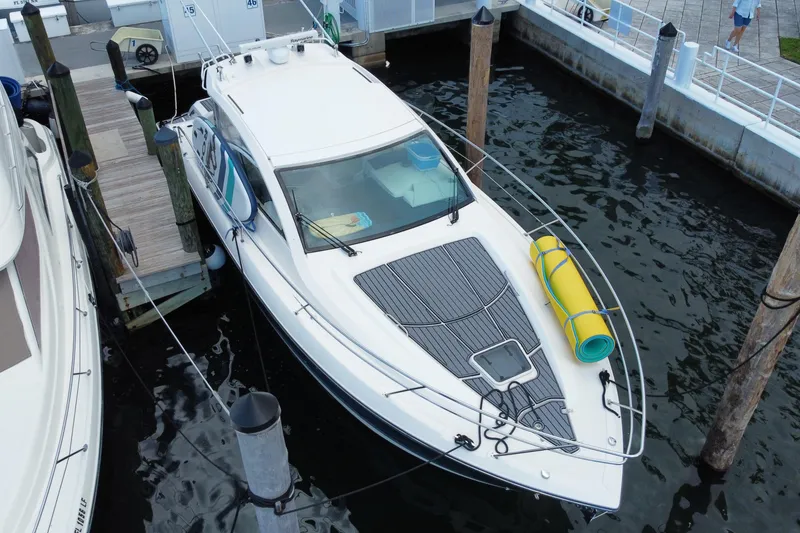 Slide: The Image of 2014 Pursuit SC 365i Sport Coupe docked at marina, calm water, cloudy sky. - 5