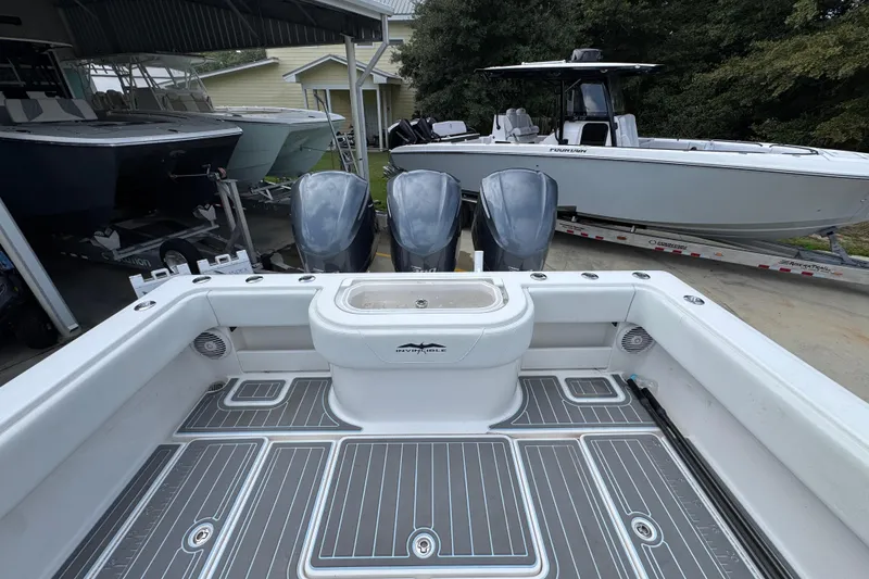 Slide: The Image of 2019 Invincible 39 Open Fisherman boat with triple engines, docked near other boats. - 41