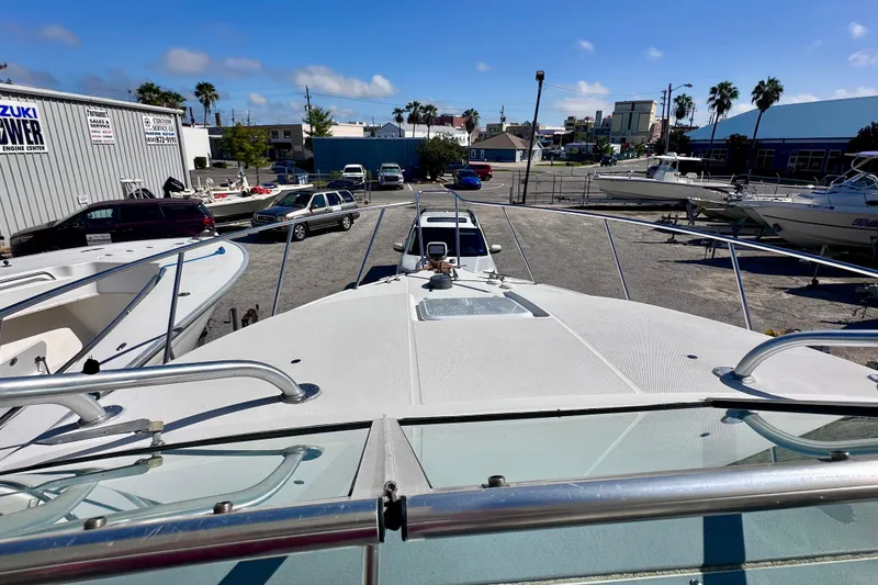 Slide: The Image of 2001 Wellcraft 290 Coastal boat on display at a marina with clear blue skies. - 10
