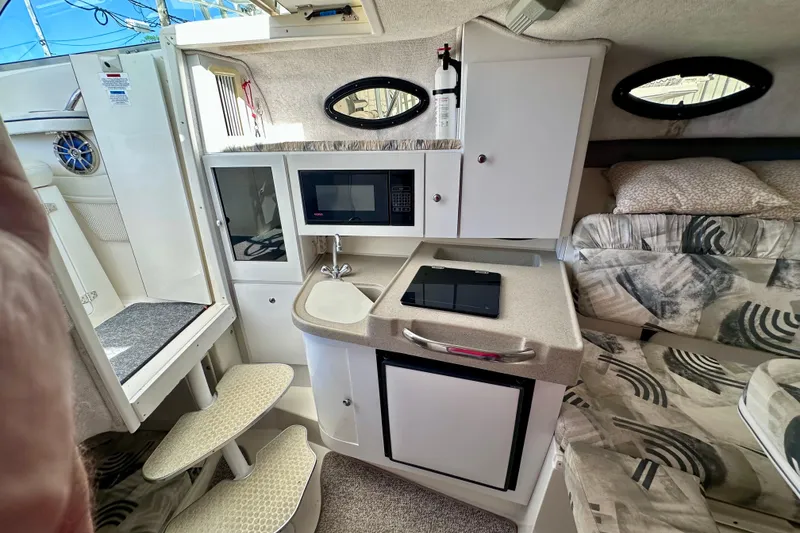 Slide: The Image of 2001 Wellcraft 290 Coastal cabin interior with kitchenette, seating, and modern amenities. - 13