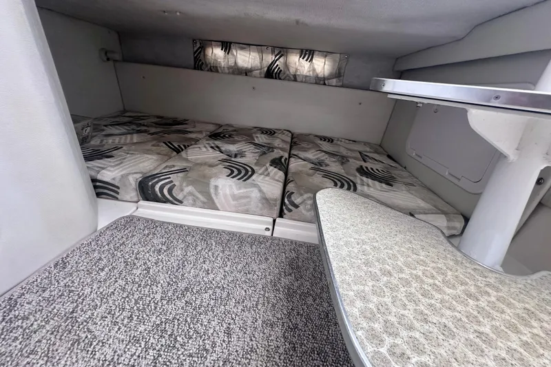 Slide: The Image of 2001 Wellcraft 290 Coastal cabin interior with patterned cushions and carpeted flooring. - 17