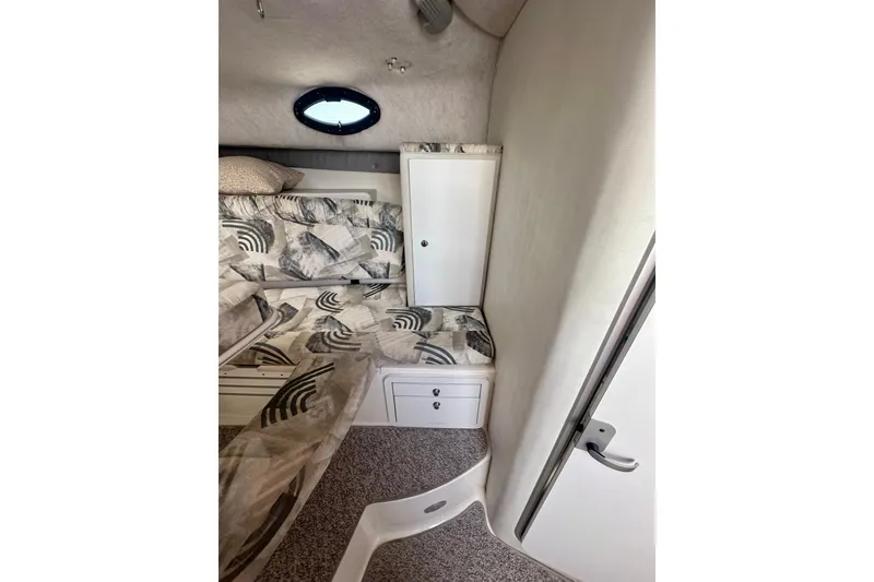 Slide: The Image of 2001 Wellcraft 290 Coastal cabin interior with patterned bedding and storage compartments. - 20