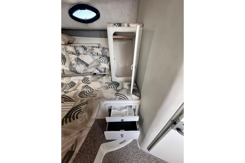 Slide: The Image of Interior of 2001 Wellcraft 290 Coastal boat with patterned bedding and open storage drawers. - 21