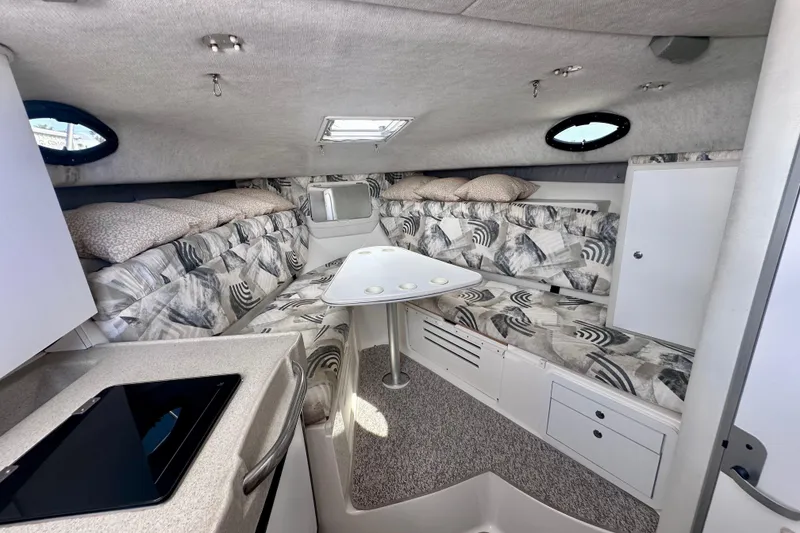 Slide: The Image of 2001 Wellcraft 290 Coastal cabin interior with patterned seating, table, and storage. - 22