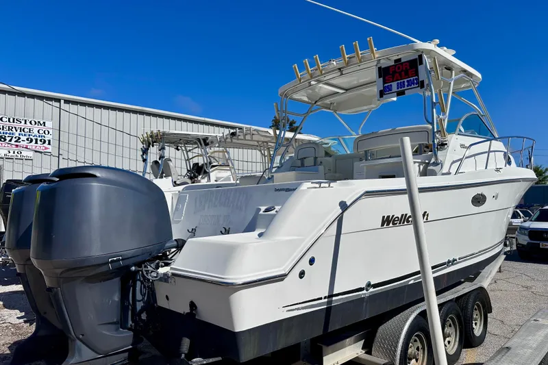 Slide: The Image of 2001 Wellcraft 290 Coastal boat for sale, dual engines, parked on trailer. - 3