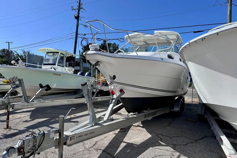 Slide: The Image of 2001 Wellcraft 290 Coastal boat on trailer, parked outdoors under clear blue sky. - 4
